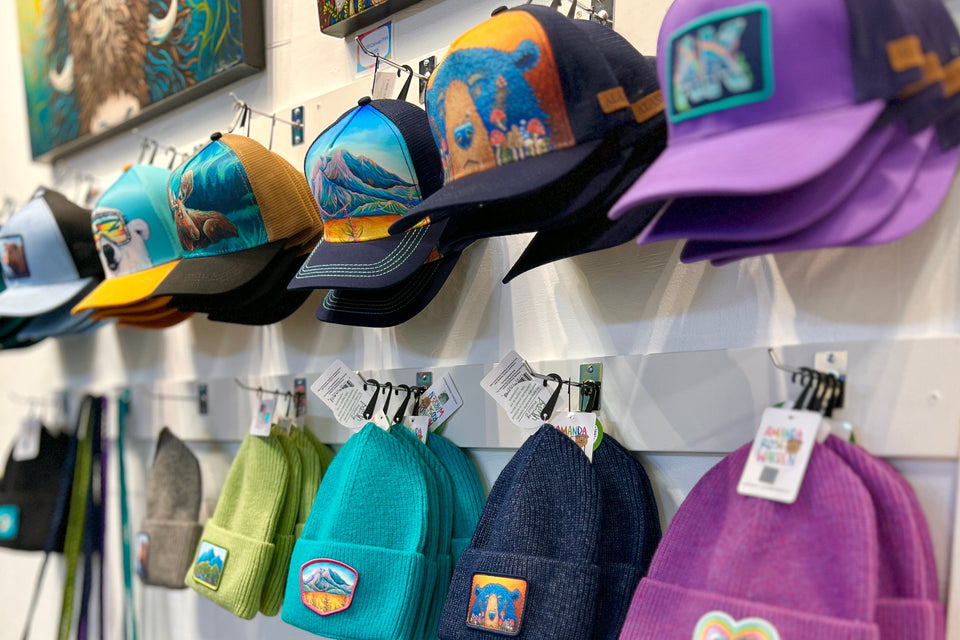 Display of colorful hats and bags with visible brand logos on a rack.