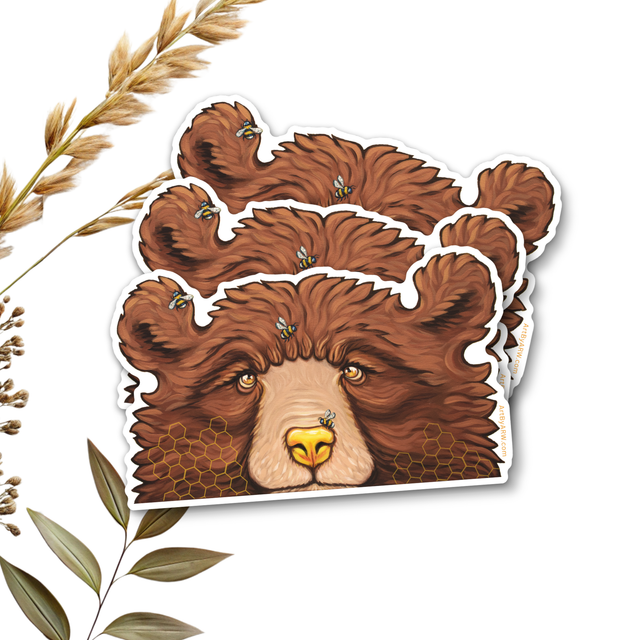 Three waterproof brown bear stickers stacked on top of each other with grass and foliage around it