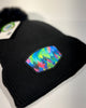 Alaska Mystic Tree pom beanie with fleece lining, showcasing vibrant rainbow forest artwork and warm cozy winter style