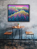 Framed colorful mountain landscape art on a textured wall above a small wooden table and stools.