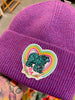 Purple beanie with a colorful patch featuring a bear and rainbow design.
