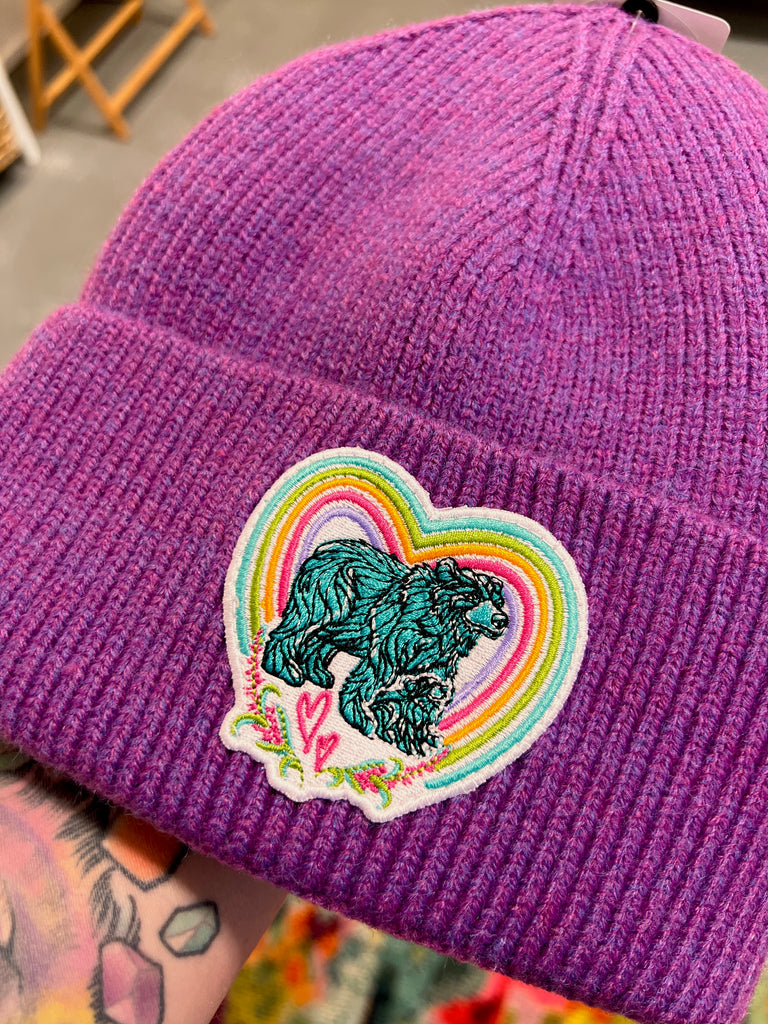 Purple beanie with a colorful patch featuring a bear and rainbow design.