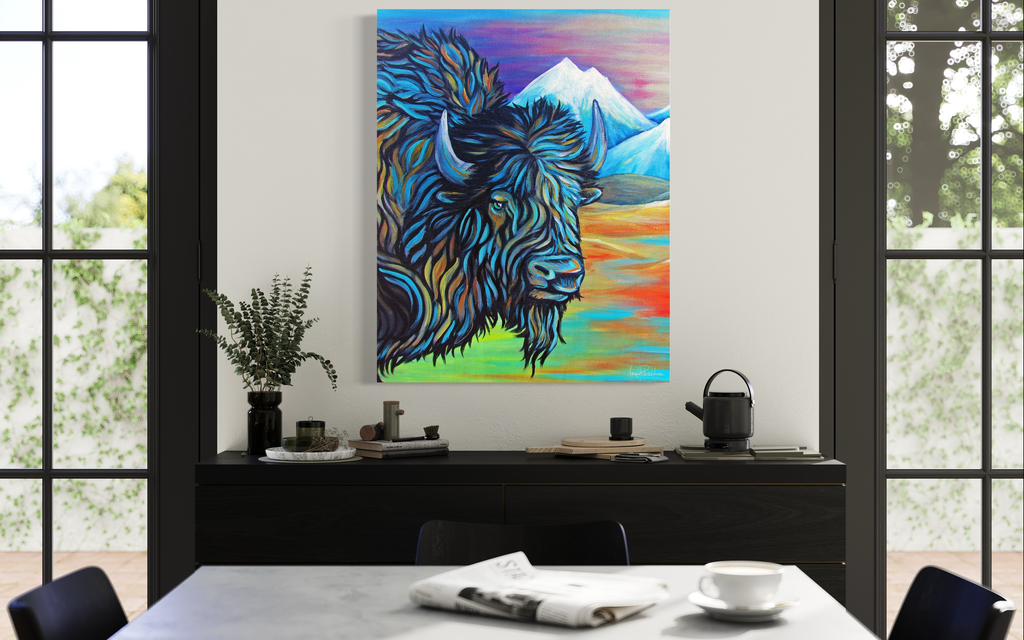 Colorful painting of a bison with mountains on a wall in a room with a table and chairs.