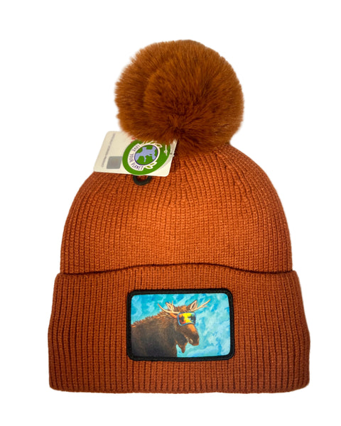 Moose Reflection rust pom beanie featuring Alaska moose design, fleece-lined knit hat with warm wildlife-inspired artwork