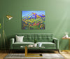 Living room with a green sofa, coffee table, and colorful mountain painting on a green wall.