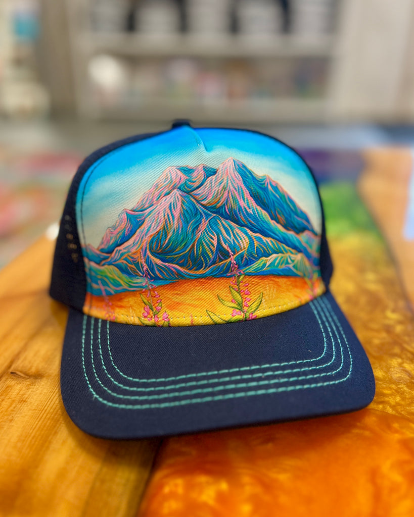 Navy Sunlit Denali trucker hat with Alaska landscape design, adjustable mesh cap featuring glowing mountain scenery