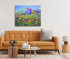 Living room with a mustard yellow sofa, wooden coffee table, and colorful mountain painting on the wall.