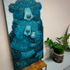 Father bear embracing momma bear and baby bear cub with a vibrant blue and hints of golden brown fur and light blue background 